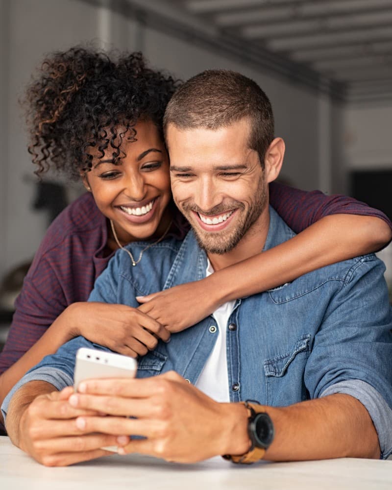 Couple smiling while looking at reviews on a phone